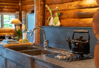 Keuken in Huys van de Boswachter met waterkoker, gaskookplaat, spoelbak en tulpen in vazen.