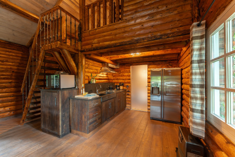 Accogliente cucina in legno e scala in una baita di Huys van de Boswachter a Sandberghe, Paesi Bassi.