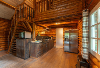 Cozy wooden kitchen and staircase inside a cabin at Huys van de Boswachter, Sandberghe, Netherlands.