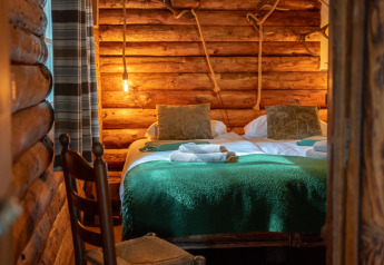 Gezellige slaapkamer van een blokhut in Huys van de Boswachter met bubbelbad, Sandberghe, Nederland.