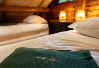 Cozy bedroom at 'Huys van de Boswachter' met Bubbelbad in Sandberghe, Netherlands with warm bedside lamps.