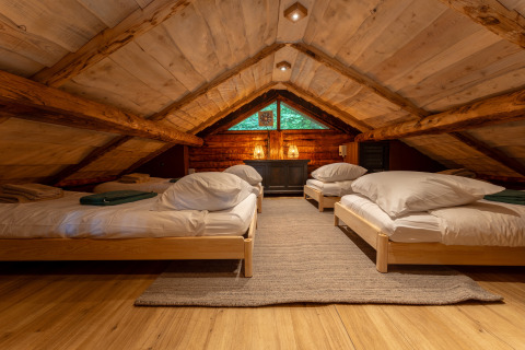 Accogliente camera mansardata con quattro letti singoli in legno al Huys van de Boswachter, Sandberghe.