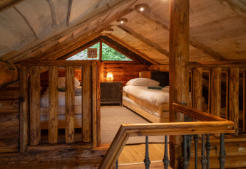 Knusse zolderkamer met twee bedden in houten lodge bij Huys van de Boswachter, Sandberghe, Nederland.