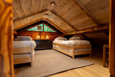Gemütliches Dachzimmer im Huys van de Boswachter, Sandberghe, mit zwei Holz-Einzelbetten und Warmlichtlampen.