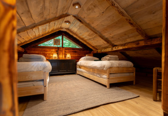 Gezellige zolderkamer met twee houten éénpersoonsbedden in Huys van de Boswachter, Sandberghe, Nederland.