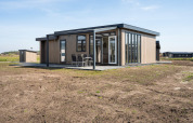 Moderna cabaña con ventanas grandes y terraza en Zandduin Deluxe, De Tien Heugten, Países Bajos.