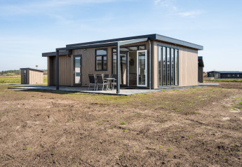 Moderne lodge met grote ramen en terras bij Zandduin Deluxe, De Tien Heugten, Nederland.