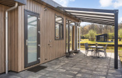 Moderno lodge Zandduin Deluxe a De Tien Heugten nei Paesi Bassi con patio coperto e sedie all’aperto.
