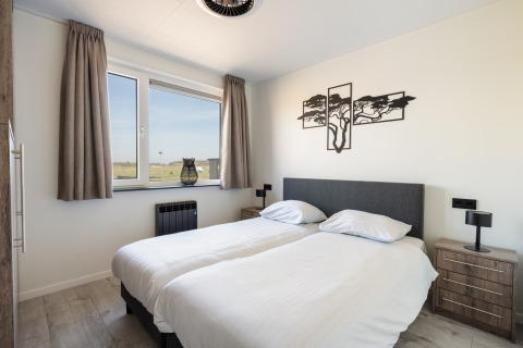 Modern ingerichte slaapkamer in Zandduin Deluxe-lodge bij De Tien Heugten, Nederland, met twee aparte bedden.