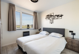 Modern ingerichte slaapkamer in Zandduin Deluxe-lodge bij De Tien Heugten, Nederland, met twee aparte bedden.