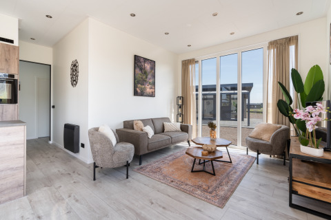 Acogedora sala de estar moderna en Zandduin Deluxe, De Tien Heugten, con ventanales amplios y decoración natural.