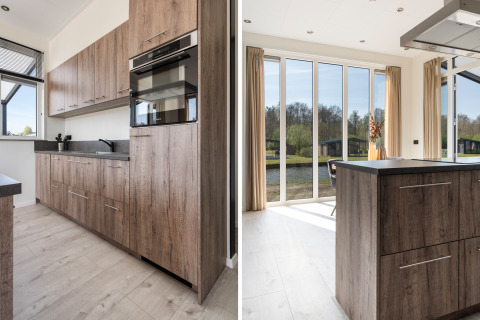 Moderne keuken met houten kasten en grote ramen in Zandduin Deluxe lodge bij De Tien Heugten, Nederland.