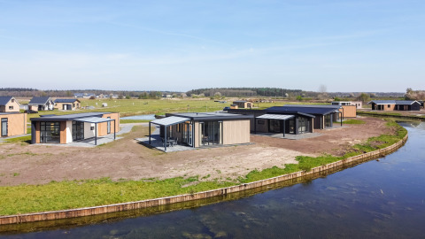 Lodges modernos Zandduin Deluxe junto al agua en De Tien Heugten, Países Bajos, rodeados de naturaleza.