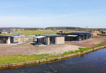 Moderne Zandduin Deluxe lodges aan het water in vakantiepark De Tien Heugten, Nederland, met natuurzicht.