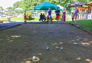 People playing pétanque on a sunny day at Camping La Colline holiday park in Belgium Luxembourg, Belgium.