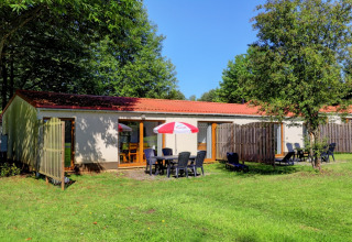 Chalet de vacances au Camping La Colline en Belgique Luxembourg, avec salon de jardin et parasol en extérieur.