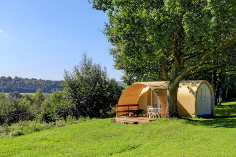 Camping La Colline: A glamping lodge tent with terrace under trees and scenic views in Belgian Luxembourg.