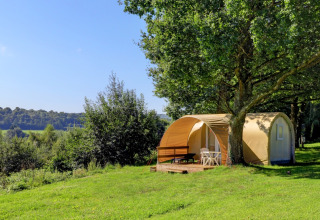 Camping La Colline: Tienda tipo cabaña con terraza bajo árboles, rodeada de naturaleza en Luxemburgo belga.
