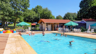 Piscina al aire libre con huéspedes nadando y tumbonas en Camping La Colline, Bélgica Luxemburgo.