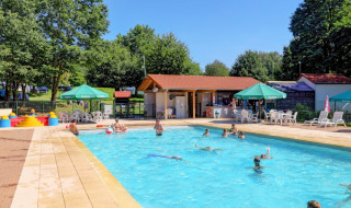 Piscina al aire libre con huéspedes nadando y tumbonas en Camping La Colline, Bélgica Luxemburgo.