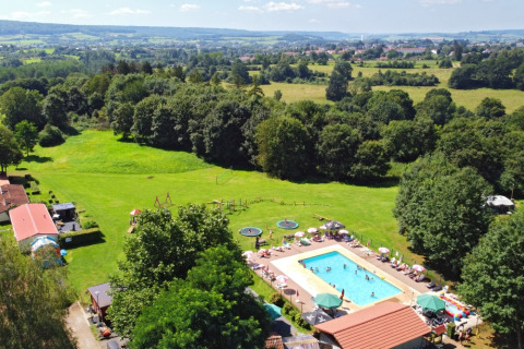 Luftaufnahme von Camping La Colline im belgischen Luxemburg, Belgien, mit Pool und grüner Umgebung.