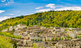 Vue panoramique d’un parc de vacances avec hébergements glamping, au bord d’une rivière et entouré de forêt.
