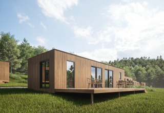 Cabaña de madera con terraza en Hameau de l'Ourthe, Bélgica, rodeada de césped verde y bosques.