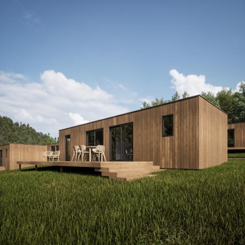 Moderne houten vakantiewoning met terras in Hameau de l’Ourthe, Luxemburg België, omgeven door natuur.