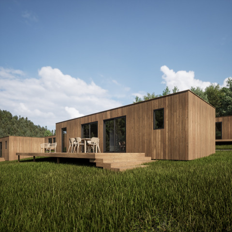 Modern wooden holiday cabin with a large terrace and outdoor seating at Hameau de l'Ourthe, Belgium.