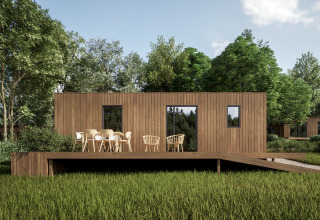 Modern wooden cabin with a deck surrounded by lush greenery, Hameau de l'Ourthe holiday park, Belgium Luxembourg.