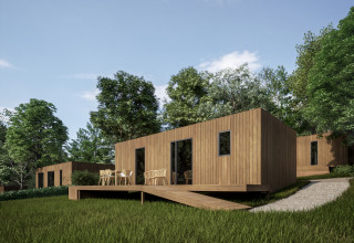 Moderne houten vakantiewoningen met terras in het Hameau de l'Ourthe, België, omringd door groen.