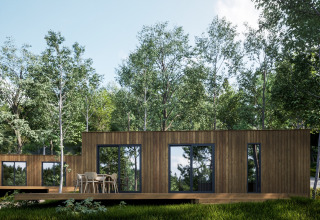 Modern wooden cabins surrounded by lush trees at Hameau de l'Ourthe holiday park in Belgian Luxembourg.