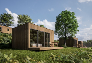 Moderne hytter i træ med store vinduer og terrasser, omgivet af grøn natur i Hameau de l'Ourthe, Belgien.