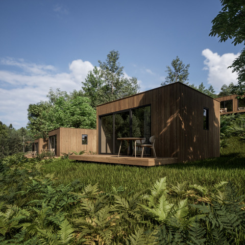 Moderne houten chalets met glazen schuiframen in Hameau de l'Ourthe, vakantiepark in Belgisch Luxemburg.