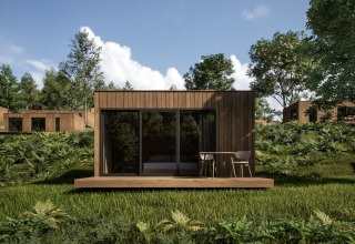 Modern wooden cabin with terrace surrounded by greenery at Hameau de l'Ourthe holiday park, Belgium.