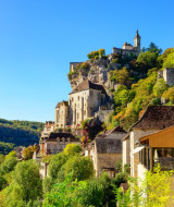 Zicht op een kerk en oude gebouwen op een heuvel bij Saint Cybranet, Nouvelle-Aquitaine, Frankrijk in de zon.