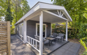 Udendørs terrasse af Wellness Lodge for 2 personer på De Thijmse Berg, Holland, omgivet af træer.