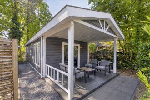 Outdoor terrace at the Wellness Lodge for 2 persons at De Thijmse Berg, Netherlands, surrounded by trees.