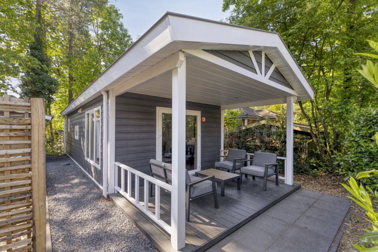 Außenansicht der Wellness Lodge für 2 Personen bei De Thijmse Berg in den Niederlanden, von Bäumen umgeben.