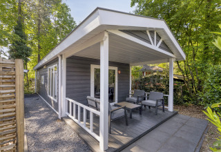 Outdoor terrace at the Wellness Lodge for 2 persons at De Thijmse Berg, Netherlands, surrounded by trees.