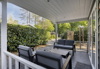 Covered patio with modern outdoor seating at Wellness Lodge for two at De Thijmse Berg, Netherlands.