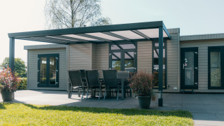 Villa Veluwe en el parque vacacional De Boshoek, Países Bajos, con terraza techada y comedor exterior.