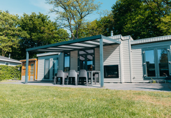 Vue extérieure de Veluwe Villa au Holiday park De Boshoek, avec terrasse et mobilier de jardin aux Pays-Bas.