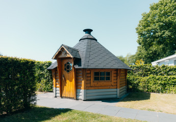 Cabaña de madera en Veluwe Villa, Holiday park De Boshoek, Países Bajos, rodeada de vegetación.