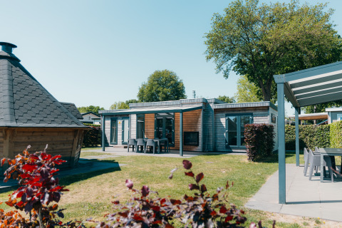 Veluwe Villa with sauna at Holiday park De Boshoek, Netherlands. Modern lodge with outdoor seating area.