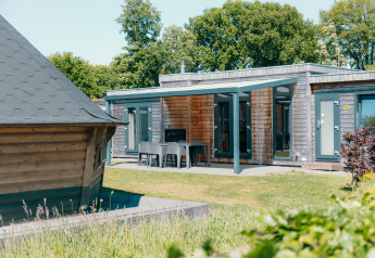 Outdoor view of Veluwe Villa with terrace and sauna at Holiday park De Boshoek in the Netherlands.
