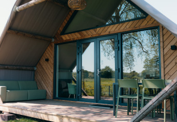 Außenansicht der Big Lodge im Holiday Park De Boshoek, Niederlande, mit Terrasse und modernen Möbeln.
