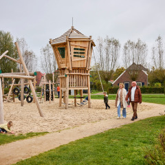 Familier nyder en legeplads med sand og træstruktur i ferieparken De Leistert, Limburg, Holland.