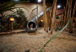 Parque infantil interior con tobogán y casita de árbol en De Leistert, Limburg, Países Bajos.