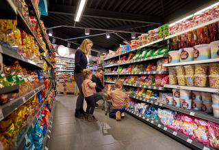 Famille faisant des courses dans une allée de snacks à De Leistert, parc de vacances à Limburg, Pays-Bas.